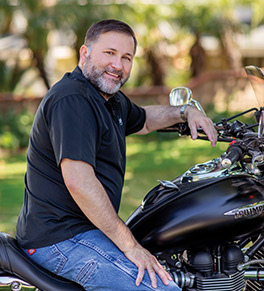 Retired Marine Corps officer Scott Shuster sits astride his Triumph motorcycle for the first time since his hip replacement.