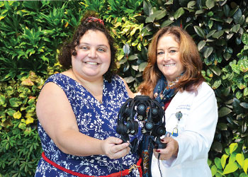 Nikki Daurio and Dr. Christine Kraus holding neurofeedback device.