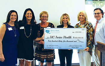 Members of the Queen of Hearts Foundation present donation check to Dr. Leslie Randall of the UCI Health gynecologic oncology team.