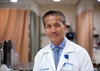 uci health colorectal surgeon ninh nguyen in a hospital area wearing a white coat and blue shirt