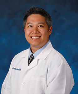 Dr. Edward Kuan smiling in his lab coat.