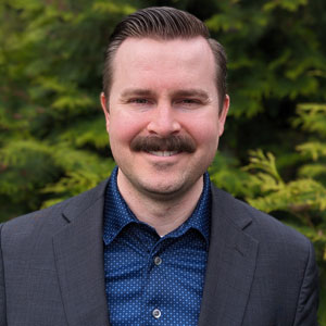uci health vice president of enterprise applications doug turner is one of becker's rising stars 40 under 40 standing outside in front of greenery