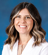 Dr. Nicole Ridolfi, pictured in her lab coat, is a UCI Health rheumatologist who specializes in the care of patients with autoimmune and musculoskeletal conditions, including rheumatoid arthritis, lupus, psoriatic arthritis, myositis and osteoarthritis.