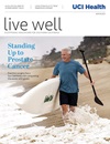Prostate cancer survivor Steve Mellem heads into the waves with his paddleboard on the cover of the winter 2023 issue of Live Well magazine. 
