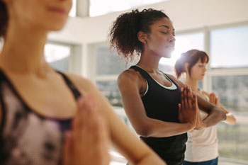 women meditating in building
