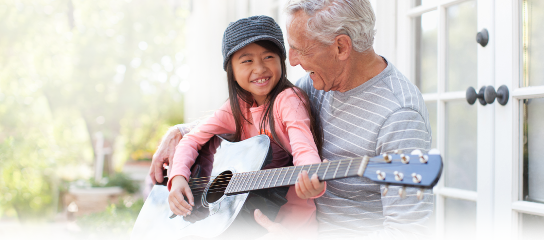 man playing guitar with granddaughter