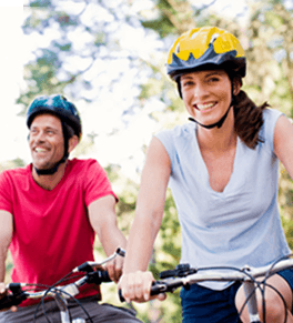 man and woman riding bikes safely