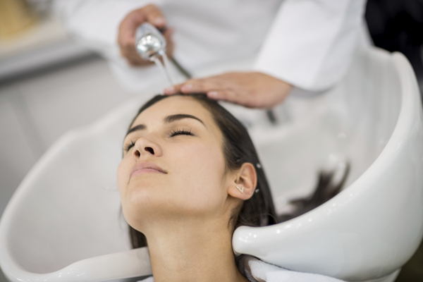 woman getting hair shampooed at salon