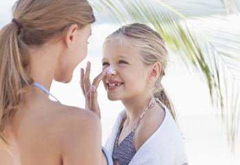 woman applying sunscreen to child's nose