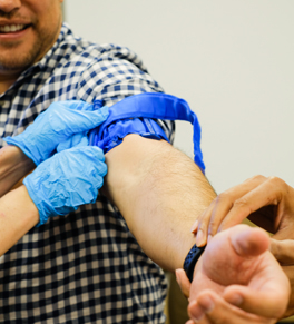 man having tourniquet tied on his arm