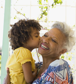 older woman getting kiss from grandson