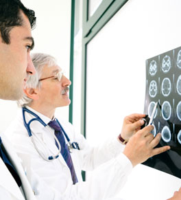 doctors examining patient brain scan for aneurysm