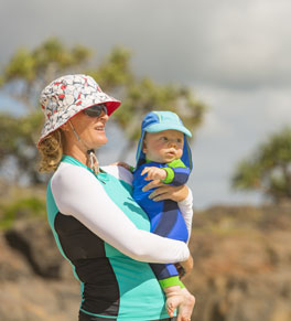 woman and baby on the beach wearing sun protection