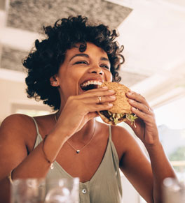 woman eating burger after intermittent fasting