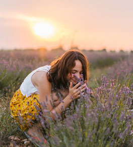woman smelling lavender in field 
