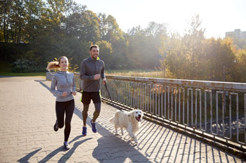 couple jogging with dog