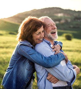 woman hugging a laughing senior man