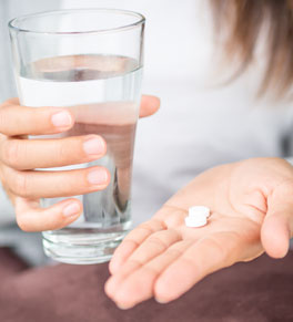 woman taking aspirin with a glass of water