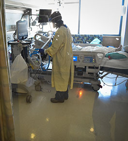 UCI Health respiratory therapist Linh Tran assists ICU patient