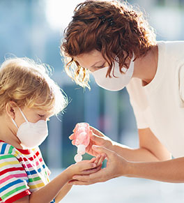 Mother applies hand sanitizer to her child's hands.