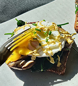 Spinach, mushrooms and poached egg on toast with tahini sauce