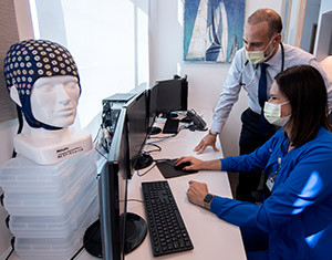 Dr. Rami Khayat and coordinator Alana Sherrill review physiological measurements from an overnight patient at the UCI Health sleep center. 