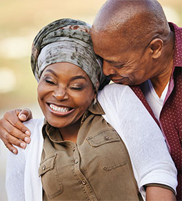 Black couple enjoys a laughing embrace.