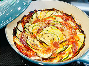 Roasted garlic ratatouille in a blue baking dish.