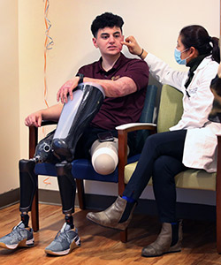 UCI Health burn specialist Dr. Theresa Chin, right, examines the burn scars on Jackson Gutierrez' face and discusses upcoming laser treatments in Dallas.