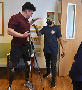 Jackson Gutierrez high fives a caregivers at the UCI Regional Burn Center during a reunion to thank the burn and trauma teams for saving his life after a fiery car crash in December, 2021.