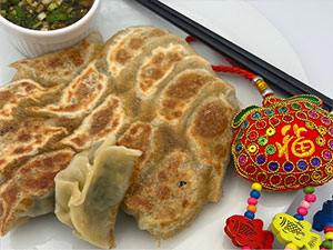 Crispy vegetarian dumplings served up with sesame dipping sauce and a red ornament are a staple for lunar new year celebrations.