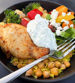 Mediterranean Chicken and Chickpea bowl served with a variety of veggies and topped with yogurt sauce.