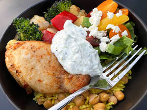 Mediterranean Chicken and Chickpea bowl served with a variety of veggies and topped with yogurt sauce. 