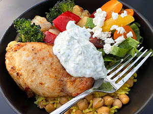 Mediterranean Chicken and Chickpea bowl served with a variety of veggies and topped with yogurt sauce.