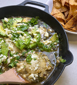 Mexican Green Shakshuka served in cast iron pan with baked tortilla chips on the side.