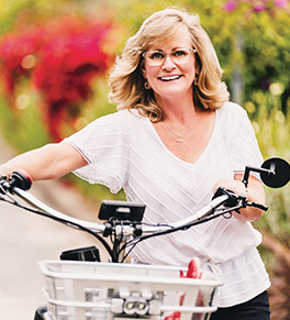 Michelle Helm, pushing her electric bicycle, fought back against her cancer diagnosis and found success with the lung cncer experts at UCI Health.