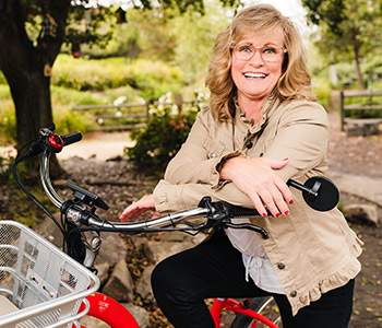 Diagnosed with terminal lung cancer, Michelle Helm, seated on her bike, found hope and recovery from her UCI Health oncology team.