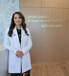 Dr. Shaista Malik stands at the entry door for the Susan Samueli Integrative Health Institute's clinical wing.