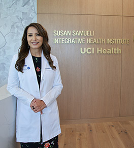 Dr. Shaista Malik stands at the entry door for the Susan Samueli Integrative Health Institute's clinical wing.