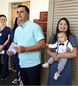 Rita Tira holding baby Landon watches happily as her husband, Fabian, hands out thank you letters to the doctors and nurses.