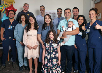 Tira family surrounding by UCI Health doctors and nurses.