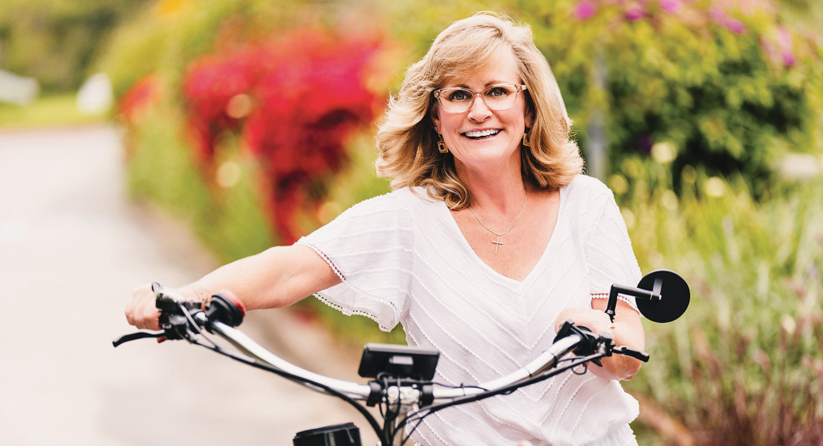 Michelle Helm, pictured pushing her electric bike, fought back against her cancer diagnosis and found success with the lung cncer experts at UCI Health.