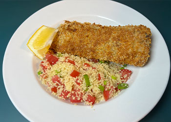Crunchy Baked Fish with Lemony Couscous displayed on white plate and lemon wedge.