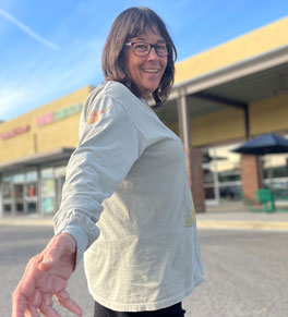 uci health epilepsy surgery patient kelly hyde outside in front of a store walking and looking sideways toward the camera
