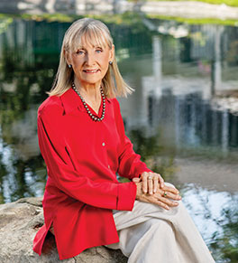Retired dance professor Janice Plastino sits on a rock overlooking a small lake during a walk near her Lake Forest home.