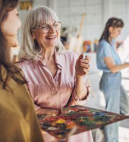 Women enjoy each other's company in a painting class.