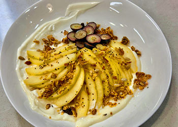 Pears poached in a honey cinnamon broth and fanned out over a bed of Greek yogurt with granola sprinkled on top.
