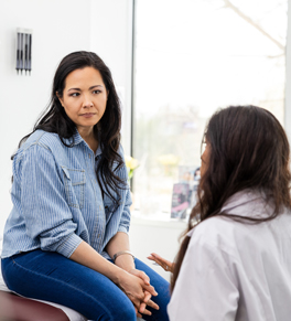 a woman sitting in her doctor's office listening as her doctor answers questions about heart health