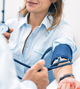 a woman having her blood pressure checked by a doctor to prevent a stroke