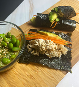 Delicious salmon avocado nori wraps are displayed on a bamboo cutting board.